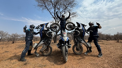 Mužský tím z krajín Beneluxu interpretuje pyramídu tak, že jeden vodič, ktorý stojí v strede na motocykli a dvíha ruky hore, zatiaľ čo ďalší dvaja vodiči postavili svoje motocykle na zadné koleso a ukazujú palce hore.