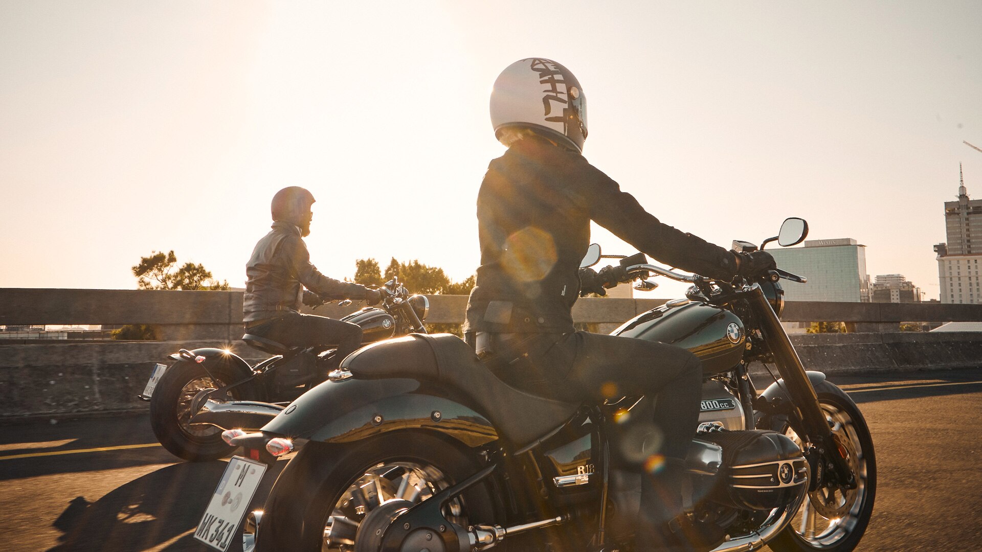 Vidíme dvoch motocyklistov v slnečnom svite.