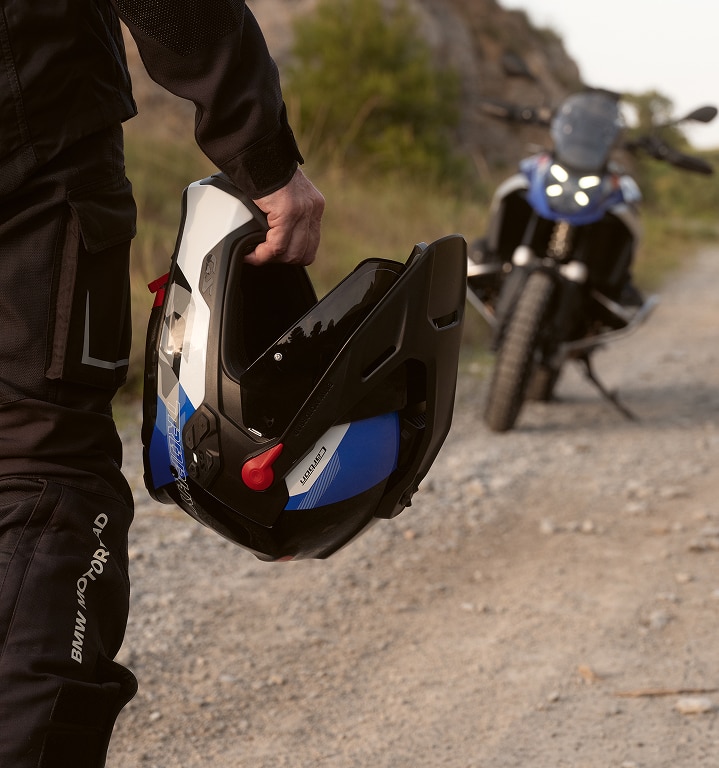Osoba drží v ruke motocyklovú prilbu.